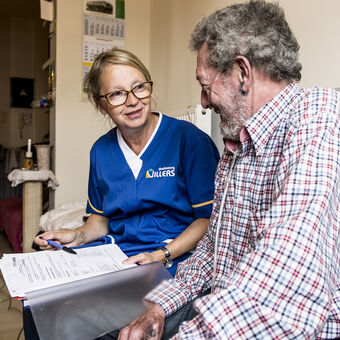 Verzorgster en man met boek